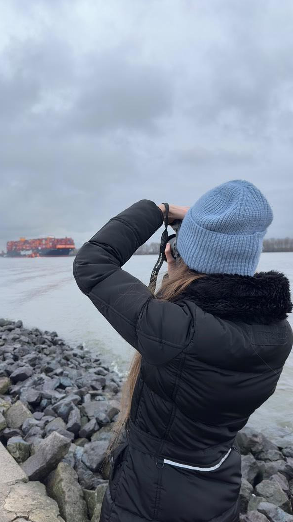 Alexandra Vogel beim fotografieren eines Frachtschiffes der Hapag Lloyd im Hamburger Hafen