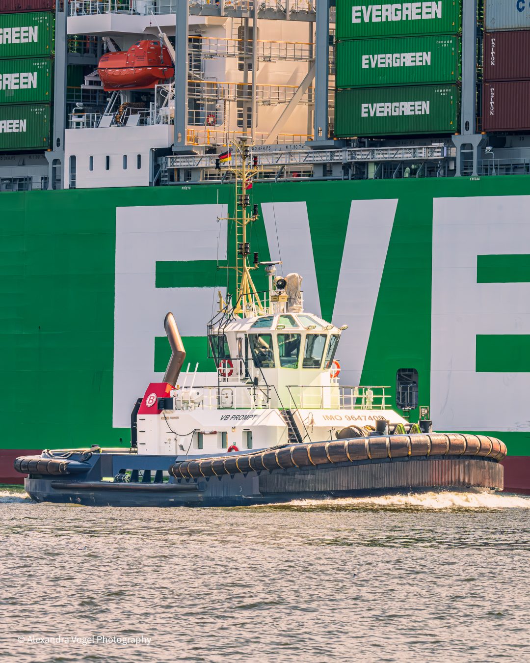 Der Schlepper VB Prompt vor einer grünen Evergreen im Hamburger Hafen